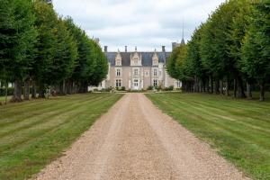 eine unbefestigte Straße vor einem Haus mit Bäumen in der Unterkunft Château de Beauvais in Azay-sur-Cher