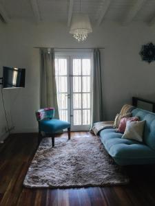 a living room with a blue couch and a window at Dpto. Tribuno in Salta