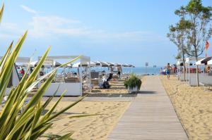 een houten promenade op een strand met parasols bij Hotel Luna in Bibione