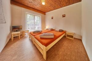 特魯特諾夫的住宿－甜蜜露營假日公園，一间卧室配有一张大床和电视