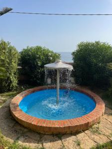 einen Brunnen in einem gemauerten Kreis mit dem Ozean im Hintergrund in der Unterkunft Villa sul mare Torretta Granitola in Granitola