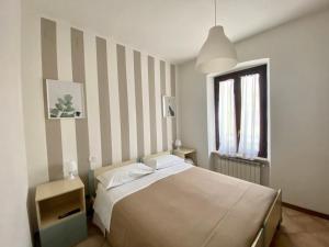 a bedroom with a bed and a striped wall at Il Casolare della Cascata in Terni