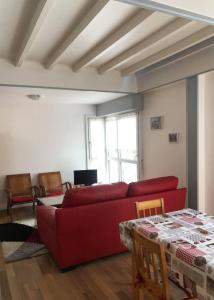 a living room with a red couch and a table at les magnolias in Colmar