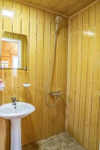a bathroom with a shower and a white sink at Cottages SHIKHRA - კოტეჯები შიხრა in Mazeri