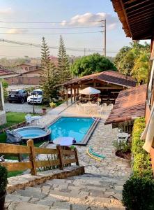 a swimming pool in a yard next to a house at Casa Santa Felicidade - Gravatá in Gravatá