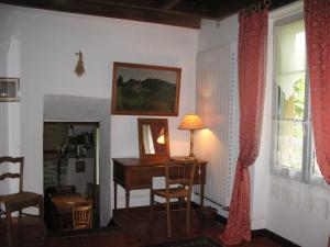 Cette chambre comprend un bureau, une table et un miroir. dans l'établissement Le Paquier De Vismoux, à Visemoux