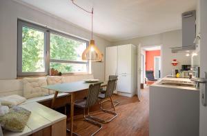 una cucina e un soggiorno con tavolo e sedie di Penthouse one a Wilnsdorf