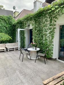 a patio with a table and chairs and ivy at Zielona Prowincja in Mysłakowice