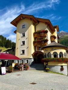 un edificio con cajas de flores en la parte delantera en Hotel Pedranzini en Santa Caterina Valfurva