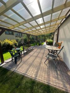 een patio met tafels en stoelen onder een pergola bij Pokoje Gdynia Demptowo in Gdynia