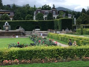 a garden with flowers and a house in the background at Wanderlust Apartment Baden-Baden in Baden-Baden