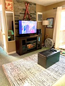 a living room with a flat screen tv on a entertainment center at Come feel what it's like to relax at 4900' in Sugar Mountain