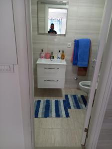 un uomo che scatta una foto di un bagno con lavandino di Apartman Savić a Bar