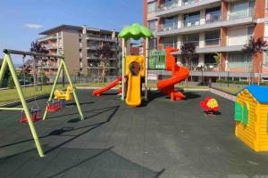 um parque infantil com equipamento de brincar em frente a um edifício em Yellow Apart @ Vitosha, Sofia em Sófia