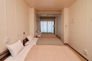 Ένα ή περισσότερα κρεβάτια σε δωμάτιο στο ゲストハウス WAKURIAN-Iwatacho