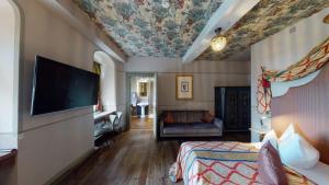 een hotelkamer met een slaapkamer met een bed en een televisie bij Schlosshotel Elgersburg in Elgersburg
