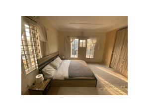 a bedroom with a bed and two windows at Amazing 4 Bedroom Duplex in Ikeja Allen Avenue in Ikeja