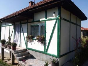 a small house with a green and white window at Kuća na selu-Mutvak- in Visoko