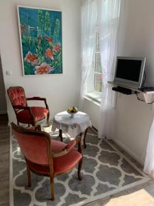 a living room with two chairs and a table and a television at Deichschatz in Mittelnkirchen