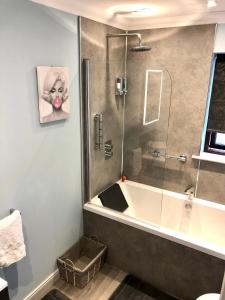 a bathroom with a tub and a glass shower at Room on the River in Cruden Bay