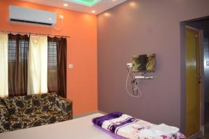 a living room with a couch and a shower at The Imperial Hotel in Rādhākishorepur +4 photos