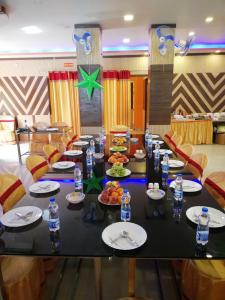 a long table with plates of food and water bottles at The Imperial Hotel in Rādhākishorepur