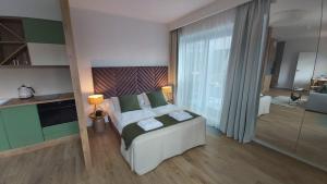 1 dormitorio con cama grande y ventana grande en IRS ROYAL APARTMENTS Apartamenty IRS Yacht Park, en Gdynia