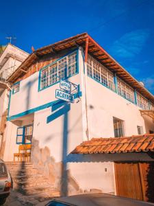 un bâtiment blanc avec un panneau sur son côté dans l'établissement Pousada Acayaca, à Diamantina