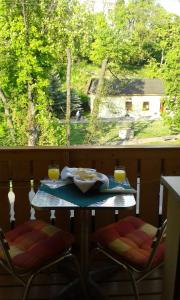 a table with two chairs and two glasses of orange juice at Penzion Centrum in Sklené Teplice