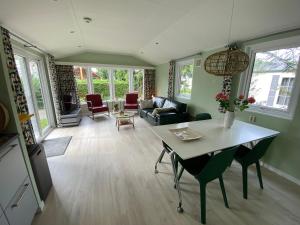 a living room with a table and chairs at Ruim en modern chalet in de Veluwse bossen in Putten