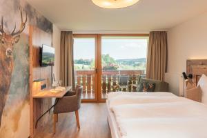 a hotel room with a bed and a desk and a window at Landgasthaus Sonne in Freudenstadt