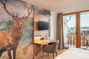 a bedroom with a painting of a deer on the wall at Landgasthaus Sonne in Freudenstadt