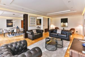 a living room with leather furniture and a dining room at Hotel California by Aycon in Sveti Stefan