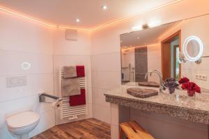 ein Badezimmer mit einem Waschbecken, einem WC und einem Spiegel in der Unterkunft Landgasthaus Sonne in Freudenstadt