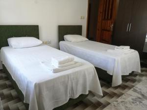 zwei Betten in einem Zimmer mit weißer Bettwäsche und Handtüchern in der Unterkunft Daltur Cıty Apart in Dalaman
