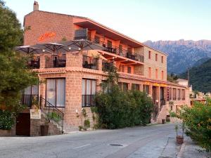 a large brick building with balconies on a street at Apparthotel Le Porto in Porto Ota
