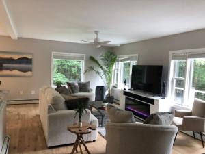un soggiorno con divani e TV a schermo piatto di The Mighty Oaks Retreat,modern house Bar Harbor Acadia MDI a Bar Harbor