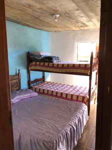 a bedroom with two bunk beds in a room at CASA RAIZ IBITIPOCA in Conceição da Ibitipoca