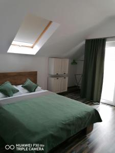a bedroom with a large bed with a green blanket at Rasnov Retreat in Râşnov