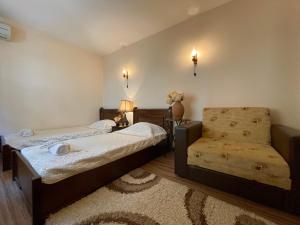 a bedroom with two beds and a chair at Hotel Slavova Krepost in Melnik +26 photos