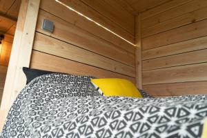 un letto in una stanza con una parete di legno di Le Moonloft insolite Tiny-House dans les arbres & 1 séance de sauna pour 2 avec vue panoramique a Osenbach