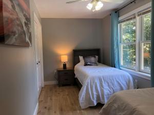 una camera da letto con due letti e una finestra di The Mighty Oaks Retreat,modern house Bar Harbor Acadia MDI a Bar Harbor
