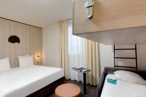 Ένα ή περισσότερα κρεβάτια σε δωμάτιο στο Kyriad Clermont-Ferrand-Sud - La Pardieu