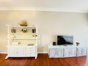a white entertainment center with a television on top of it at BILBAO AEROPUERTO in Derio