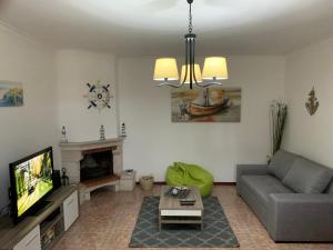 een woonkamer met een bank en een tv bij West coast dream Nazare in Nazaré