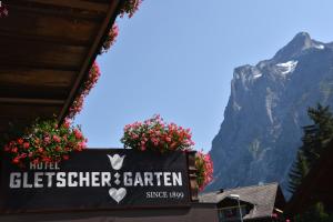 un segno per il centro agilbert con montagne sullo sfondo di Hotel Gletschergarten a Grindelwald