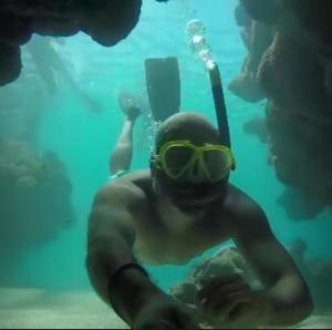 a man in a diver suit and goggles underwater at Suítes Cavalo Marinho in Porto De Galinhas