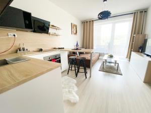 een keuken en een woonkamer met een tafel en stoelen bij Krásny moderný 1-izbový byt, novostavba + parking in Bratislava