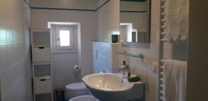 a white bathroom with a sink and a toilet at La casa della Pieve Vecchia in Marmigliaio +41 photos