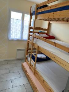 two bunk beds in a room with a window at Idéale famille, tout y est ! in Dompierre-sur-Besbre
